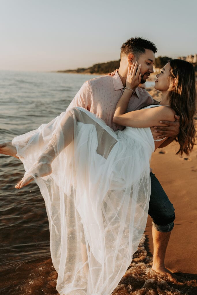 Man dip kisses a woman on the beach.