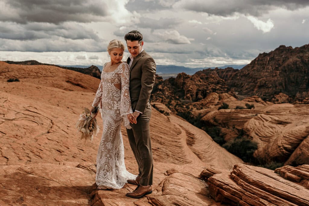 Bride and groom stand on top of petrified sand dunes during their elopement.