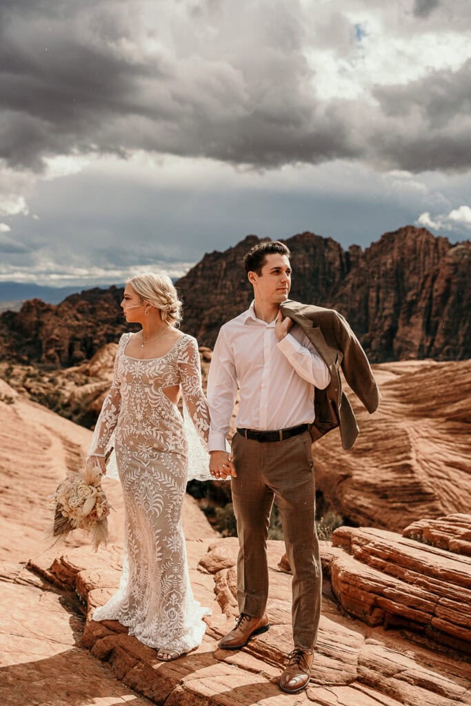 Bride and groom pose editorially on top of petrified sand dunes.