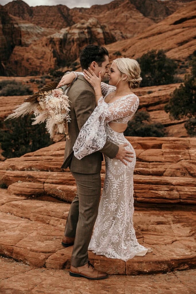 Jayson & Skyler smile into each others eyes during their elopement. The petrified sand dunes are in the background.