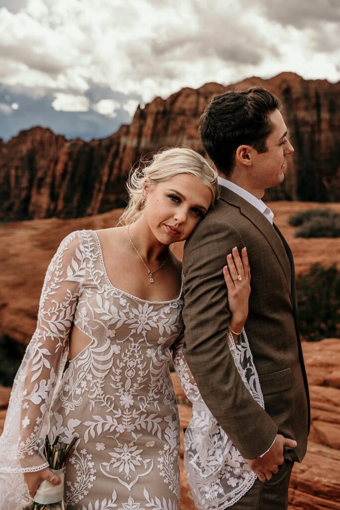 Bride looks at the camera while resting her head on the groom's shoulder.