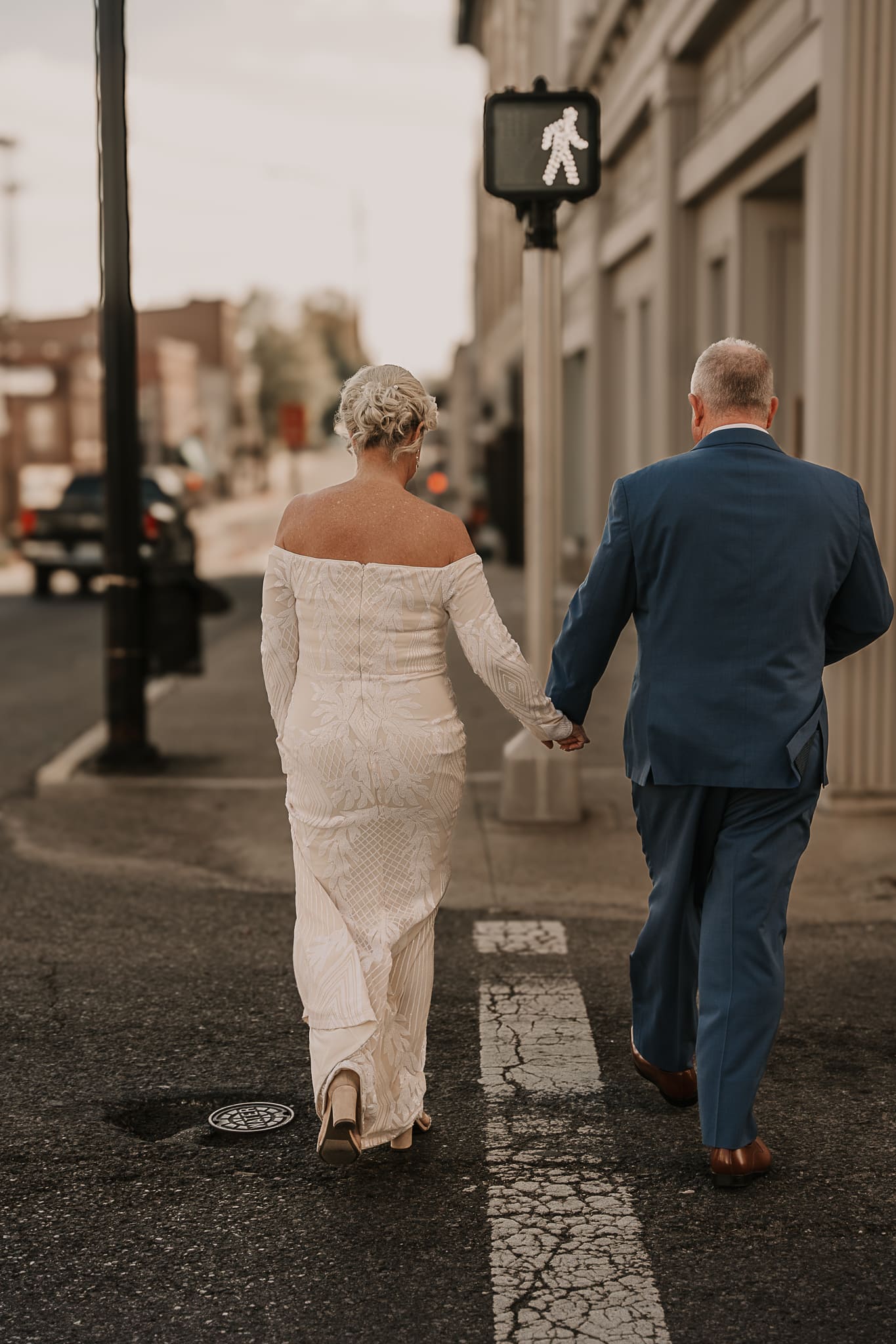 A bride and groom walk across the street in a crosswalk during their Hopkinsville wedding.