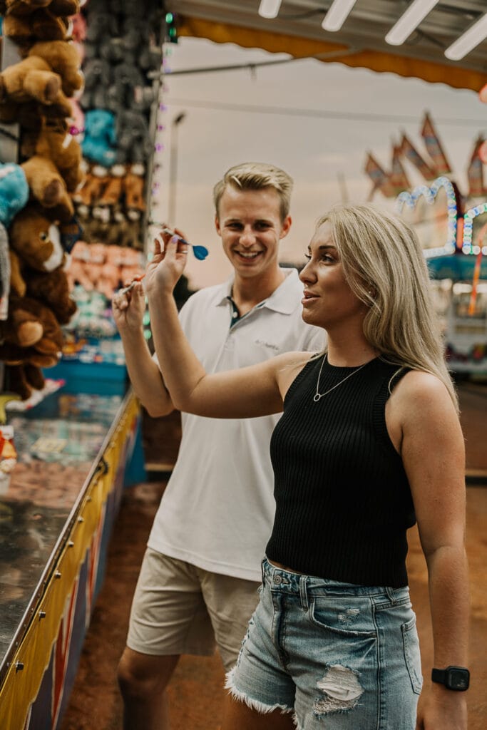 Jordan laughs while looking at Mattison as they play darts at the Montgomery County Fair.