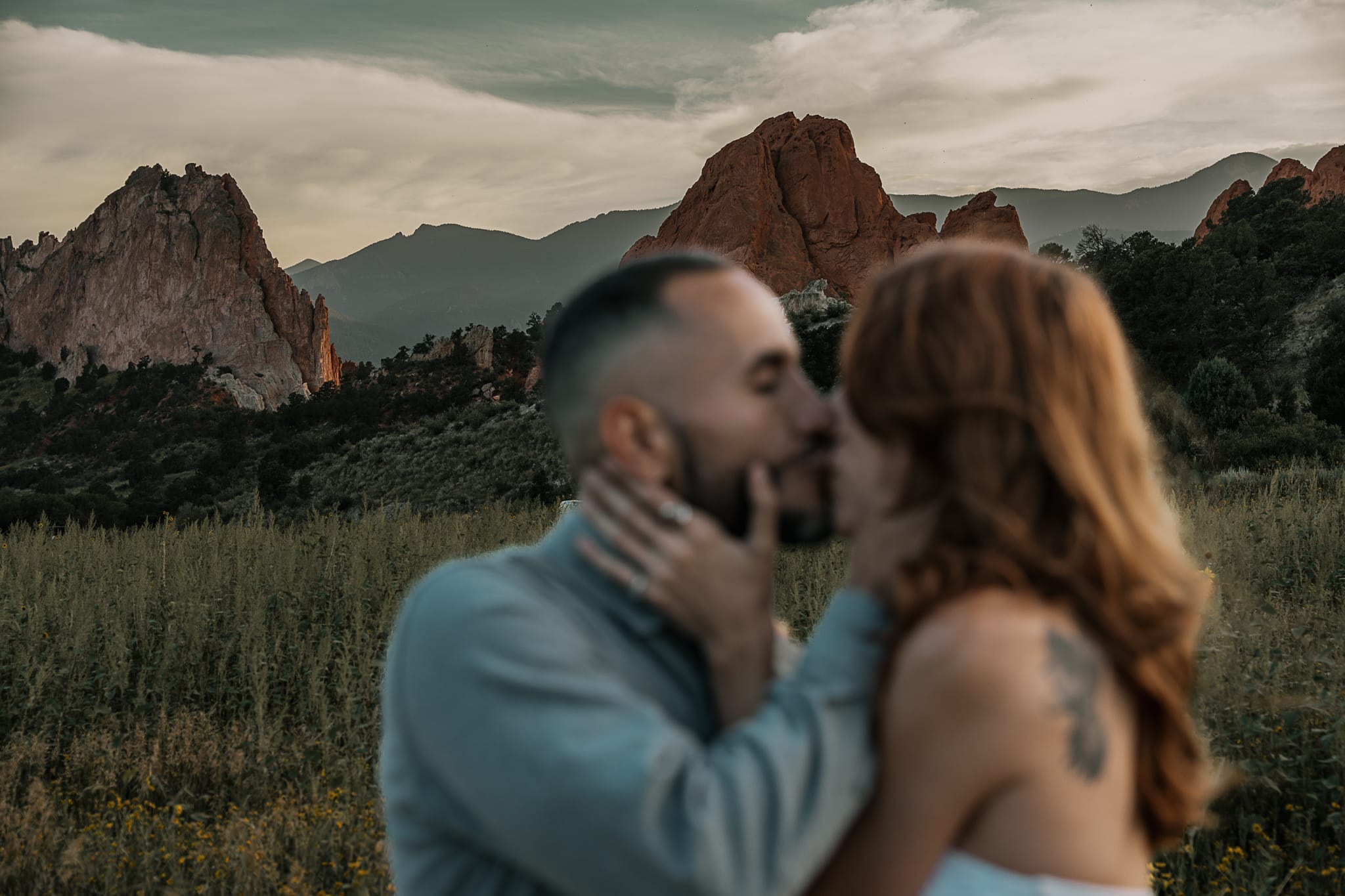 Couple kisses in Garden of the Gods, Colorado. They are blurry and the rocks are in focus behind them.