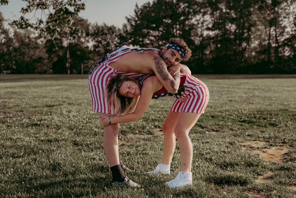 A couple poses awkwardly on purpose while bent over each other during a Masterminds photoshoot.