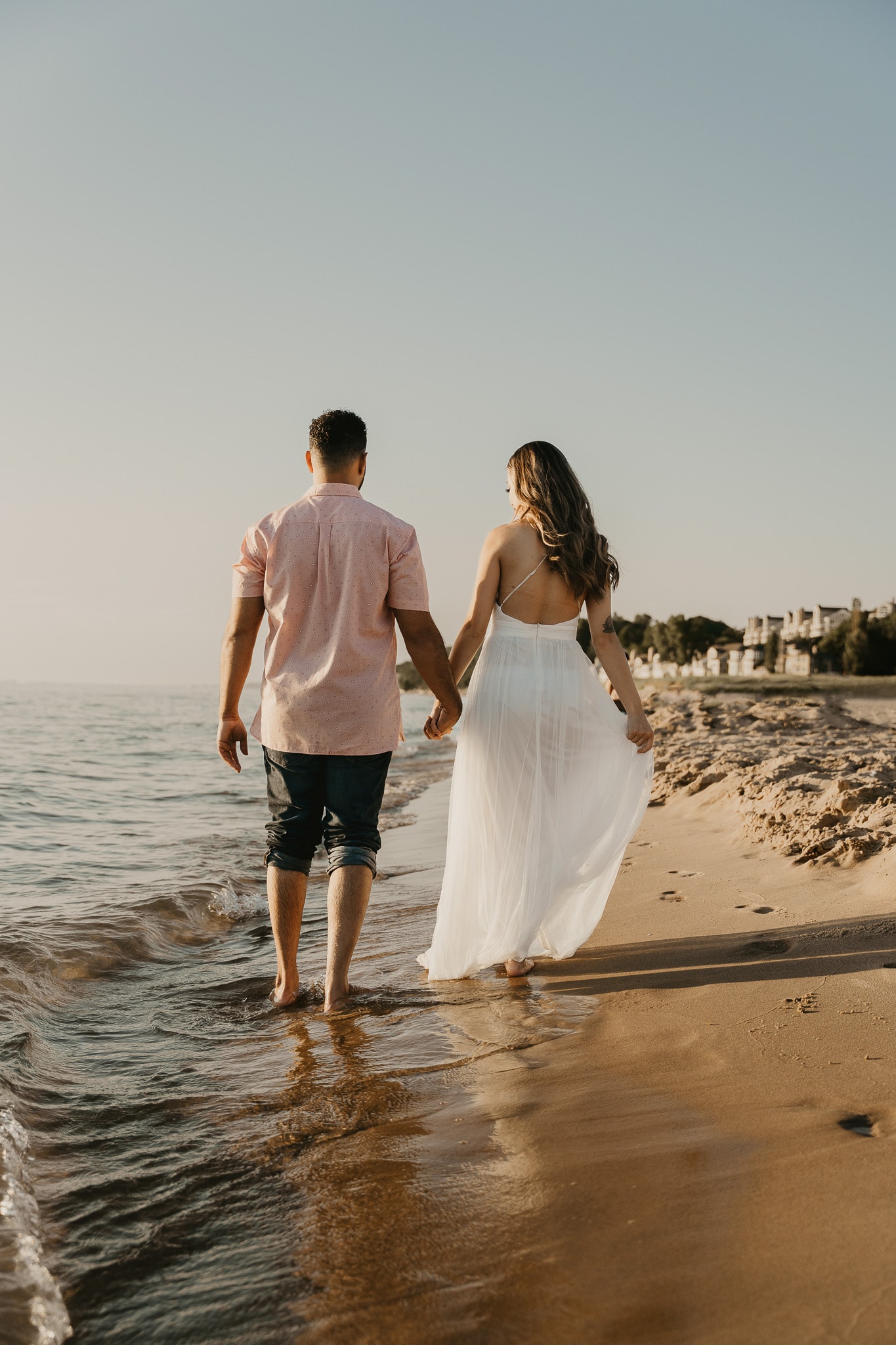 Couple walks hand in hand on Lake Michigan beach during elopement