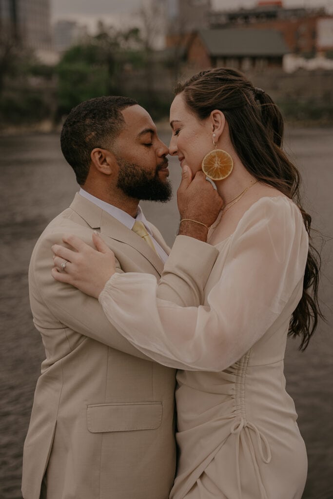 Couple stands nose to nose with their eyes closed during elopement ceremony along Cumberland River in Nashville.