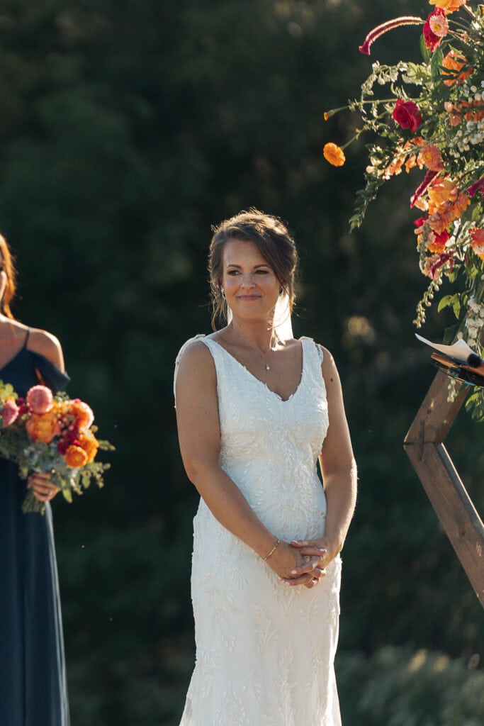 The bride smiles out at her family and friends during her outdoor wedding ceremony.