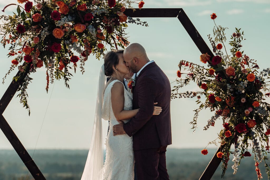 Lauren & AJ kiss at the end of the outdoor wedding ceremony.