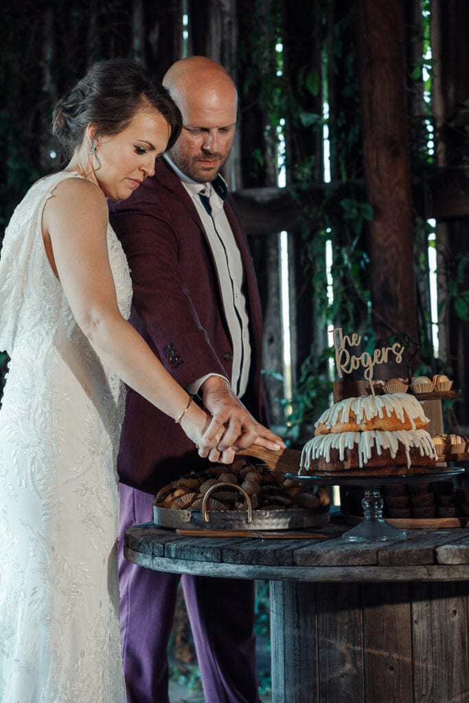 Lauren & AJ cut into their bundt cake at their wedding reception.