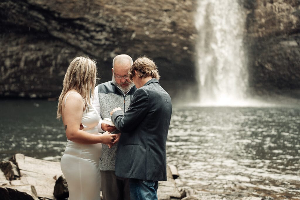 Closeup horizontal image of Ashlyn & Brent holding hands while saying their vows.