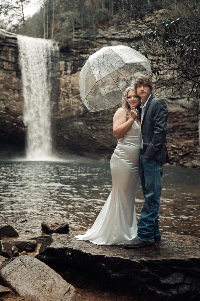 Wide angle image of couple standing on big rocks in front of Foster Falls during their elopement ceremony