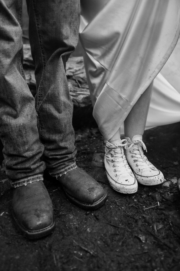 A black and white image of a couples muddy shoes during their hiking elopement.