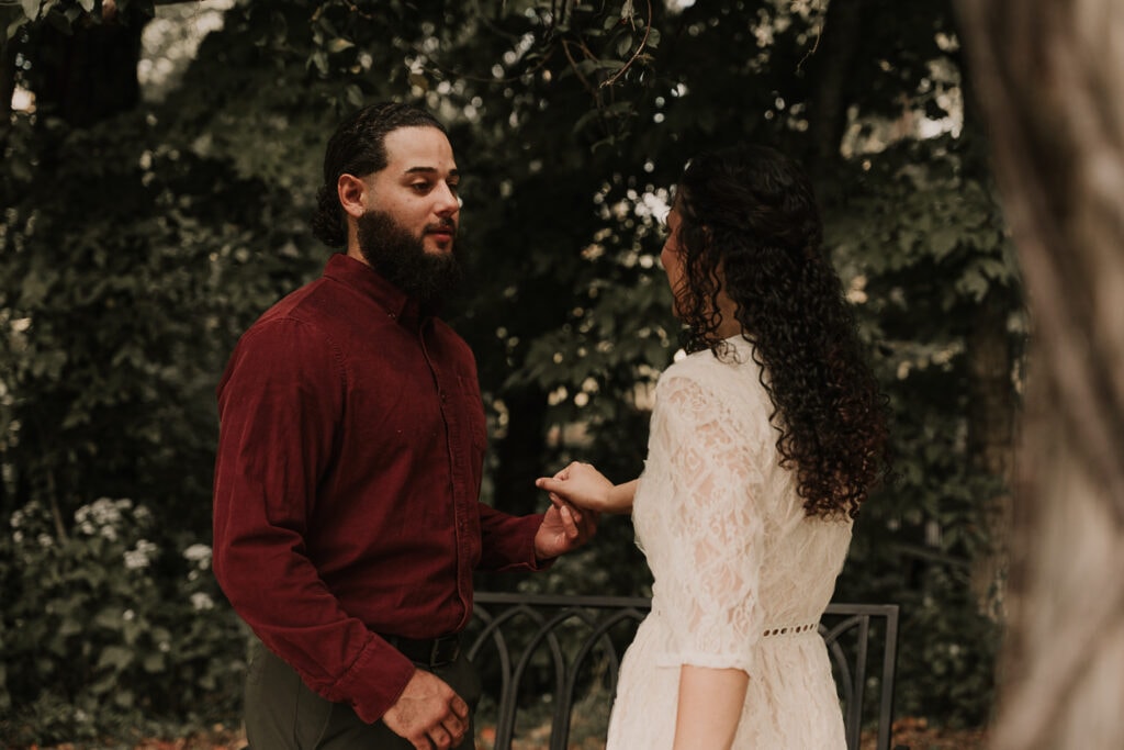 Mady & Ezekiel have their first look, as he turns around to see her while outside in a garden on their wedding day.