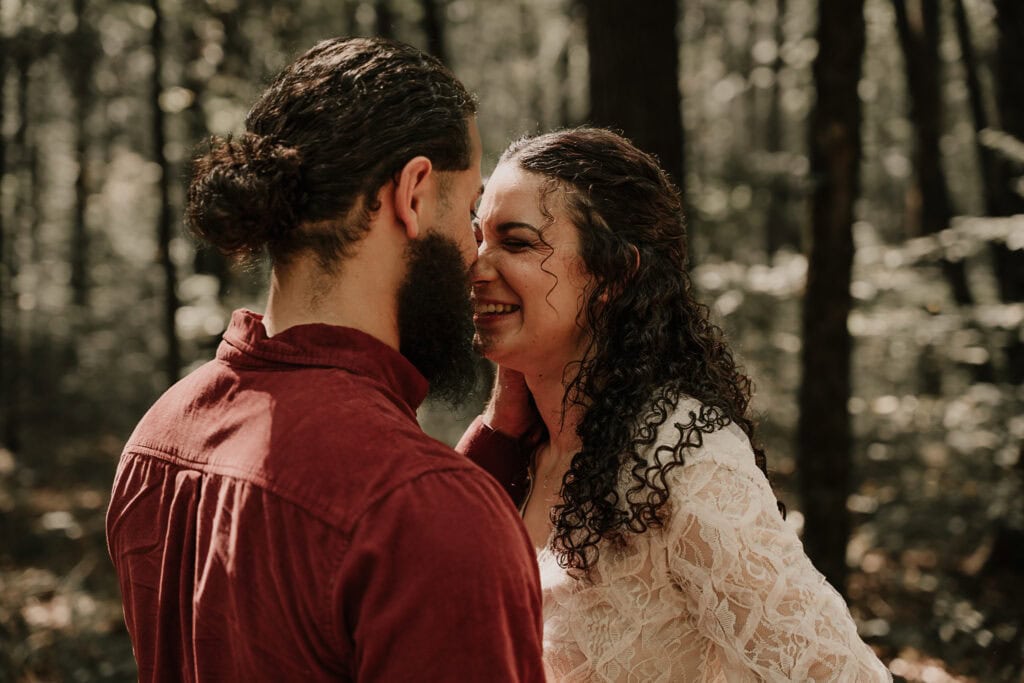 Eloping couple laughs together during their outdoor wedding ceremony.