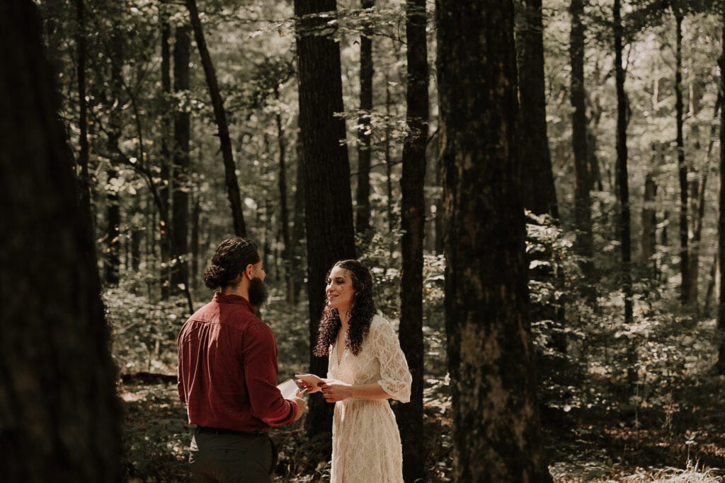 Couple exchanges vows in the forest during their elopement.