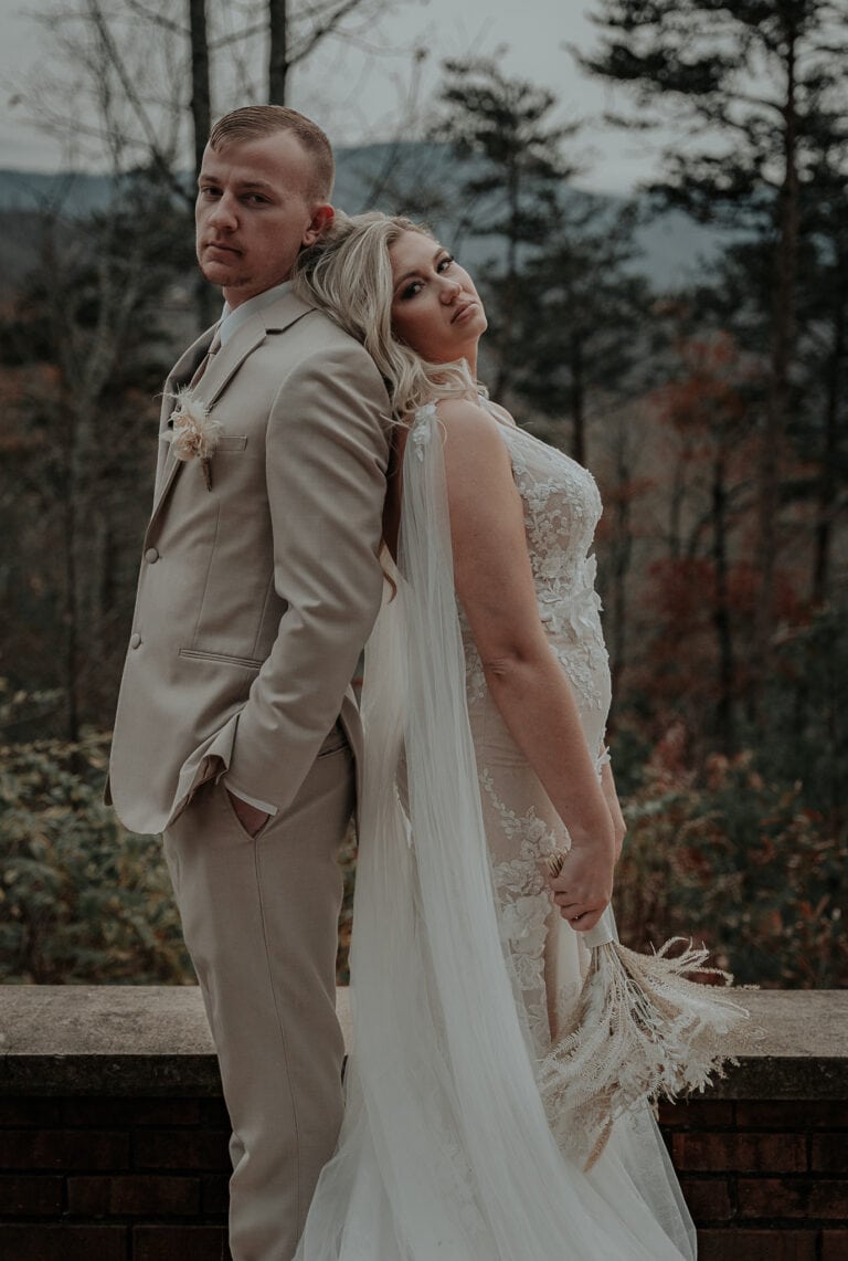 Bride and groom stand back to back at sunset with the Smoky Mountains in the background after their Gatlinburg elopement