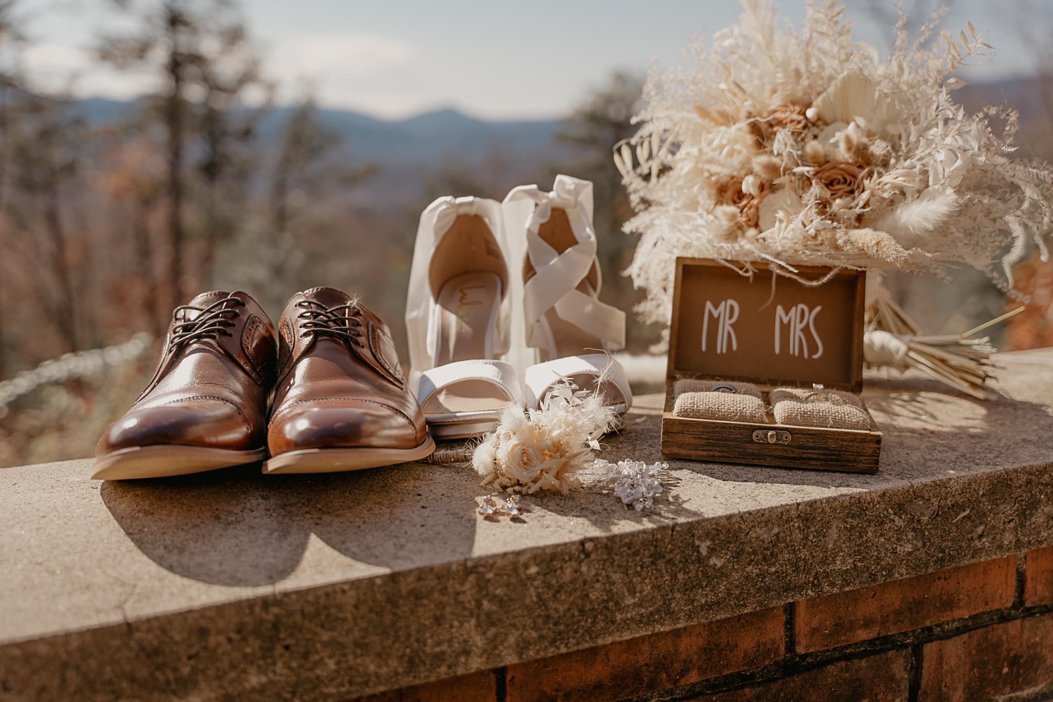 Bride & Groom's accessories & shoes on a brick wall in front of the Smoky Mountain National Park.
