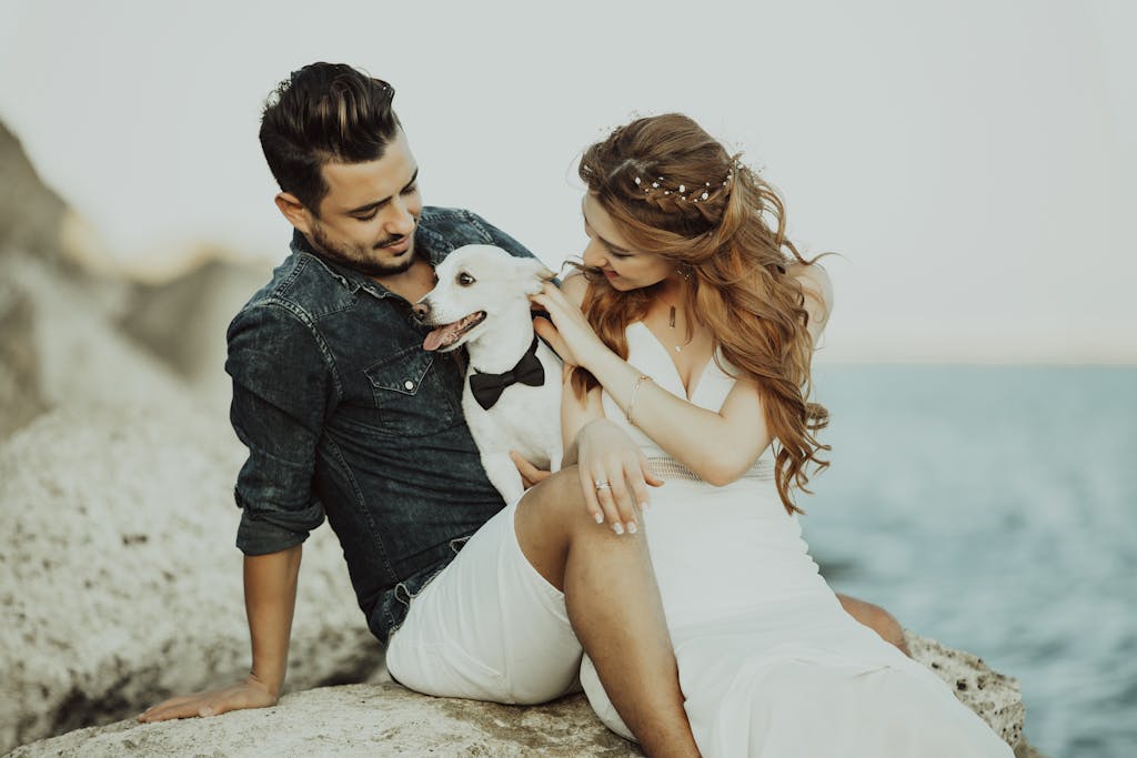 Photograph of a Woman in a White Dress Petting a Dog