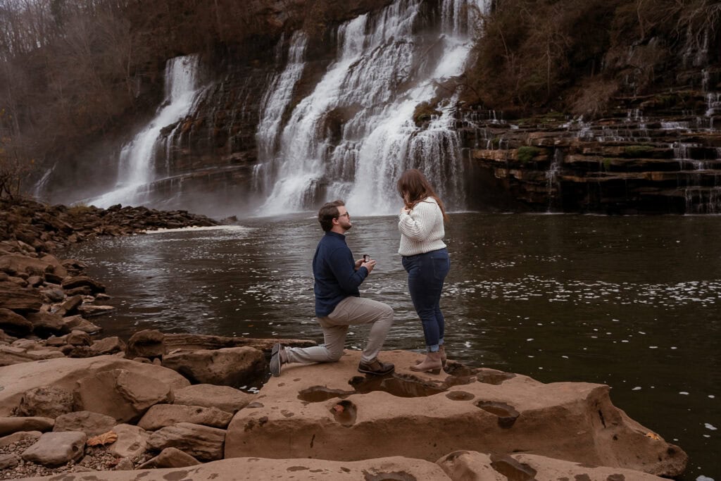 Man is on one knee in front of Twin Falls proposing to a woman.