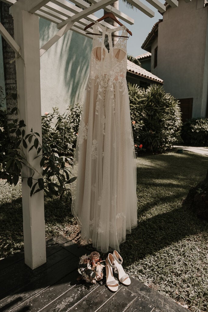 Bride's dress hangs from an arbor in the garden at Sandals.