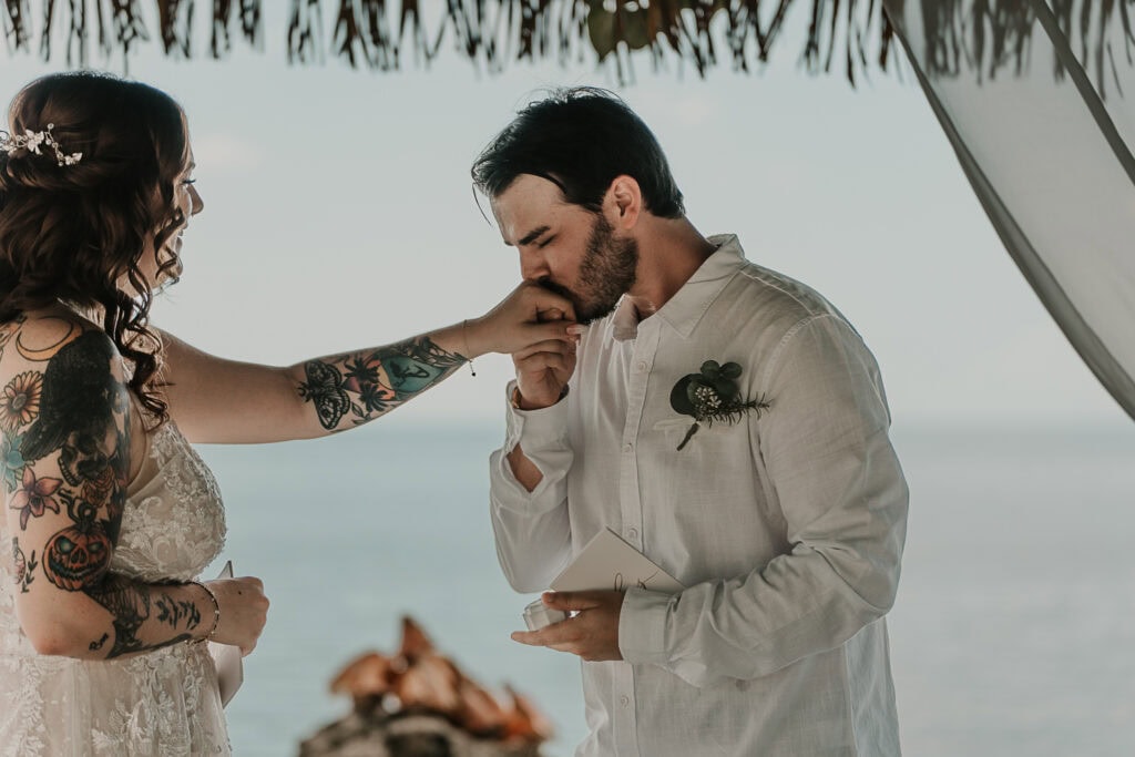 Groom kisses his bride's hand after he places the ring on her finger.