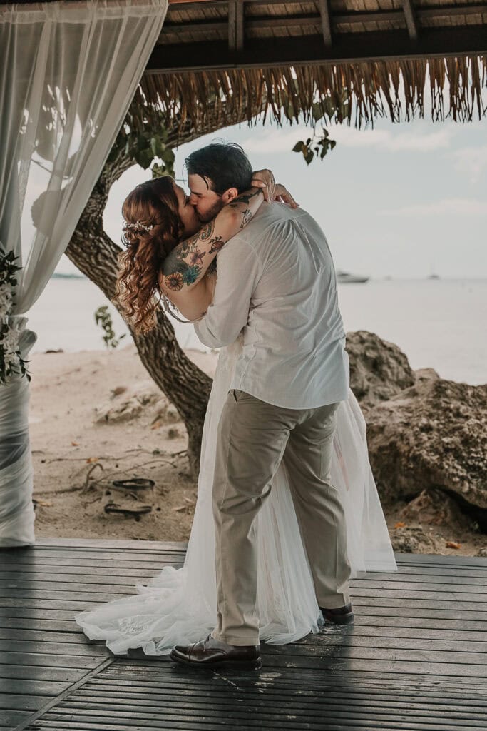 David dips Marissa in a passionate first kiss as they get married on the beach in a gazebo.