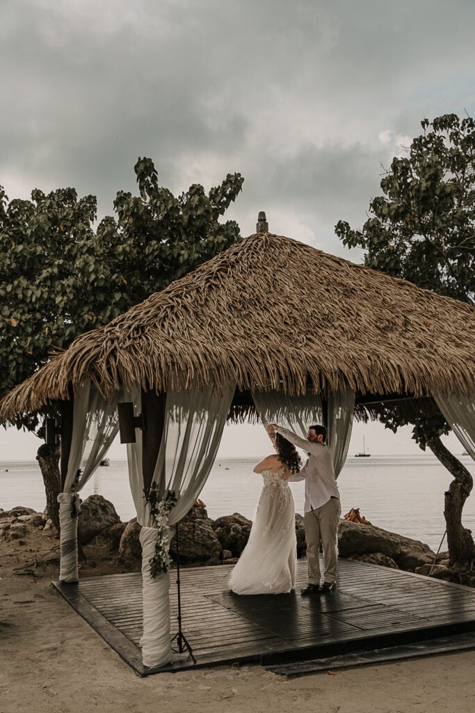 Marissa and David have their first dance in an oceanside gazebo.