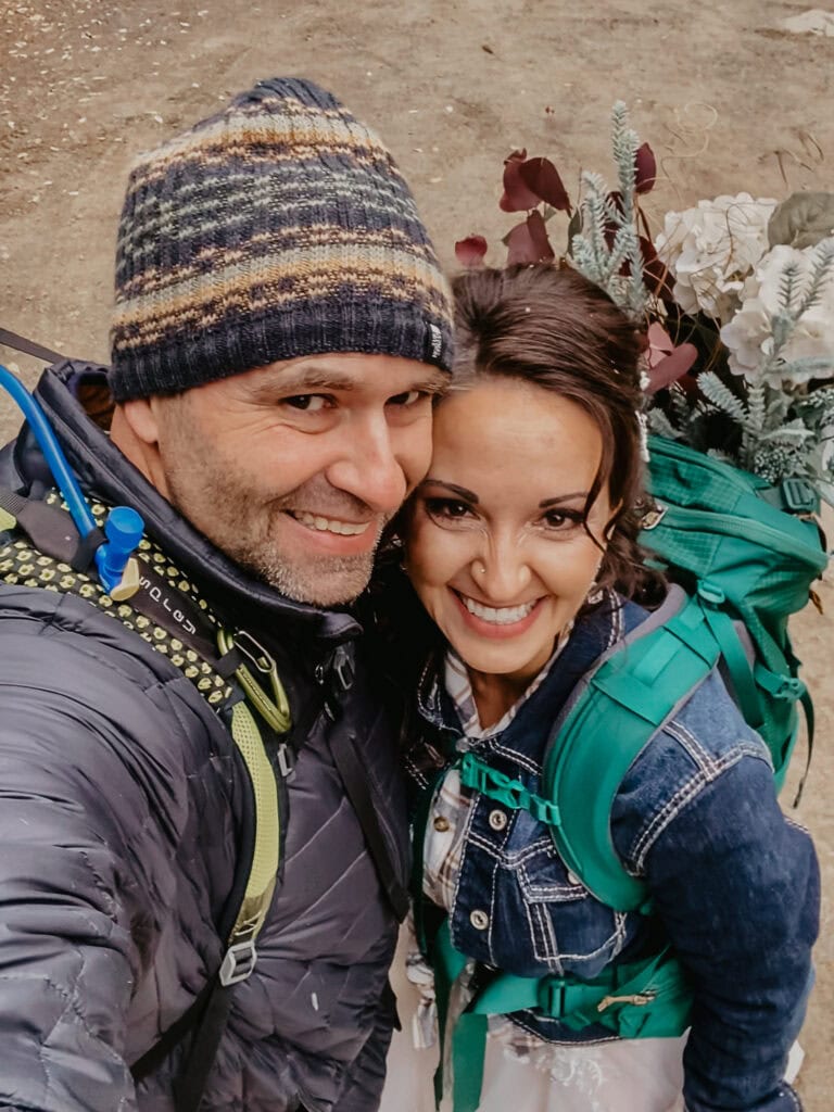 An eloping couple takes a selfie during their hike.