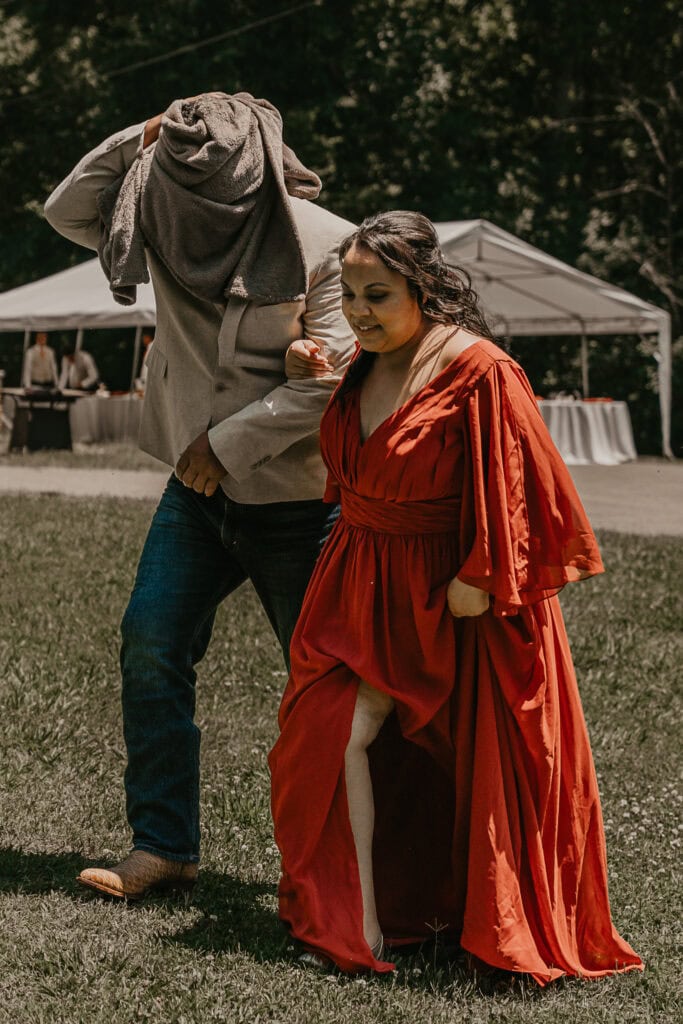 Daughter deals her dad to the first look on his wedding day. He has a blanket wrapped around his head so he won't see the bride yet.