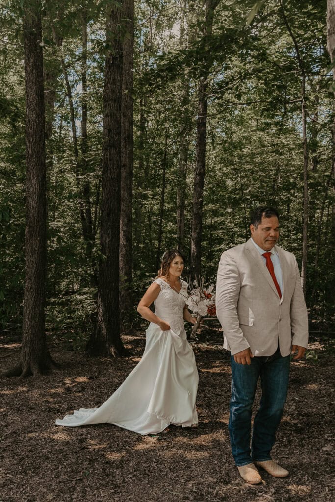 Anita walks up behind John during their wedding day first look. He can't see her yet.