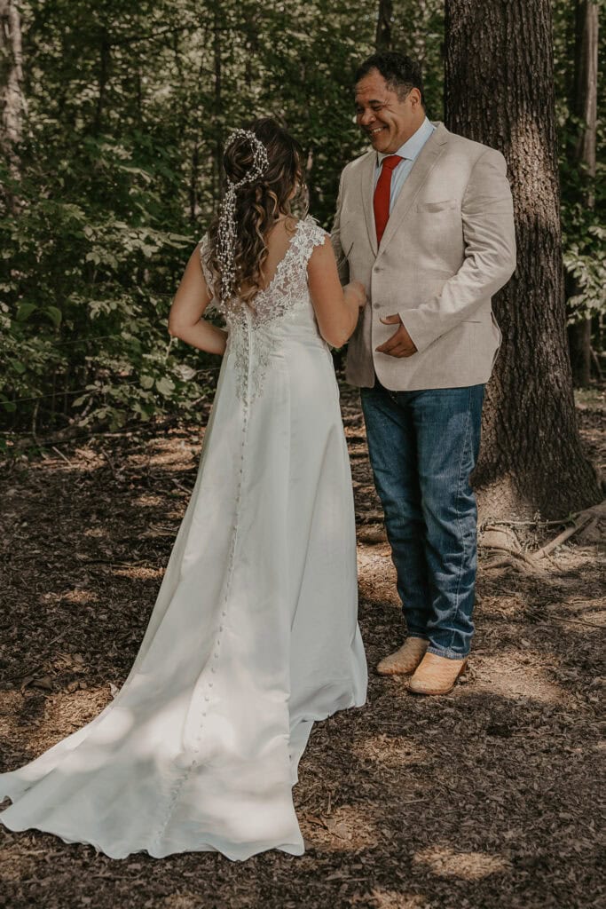 A groom looks at his bride for the first time on their wedding day. He is emotional.