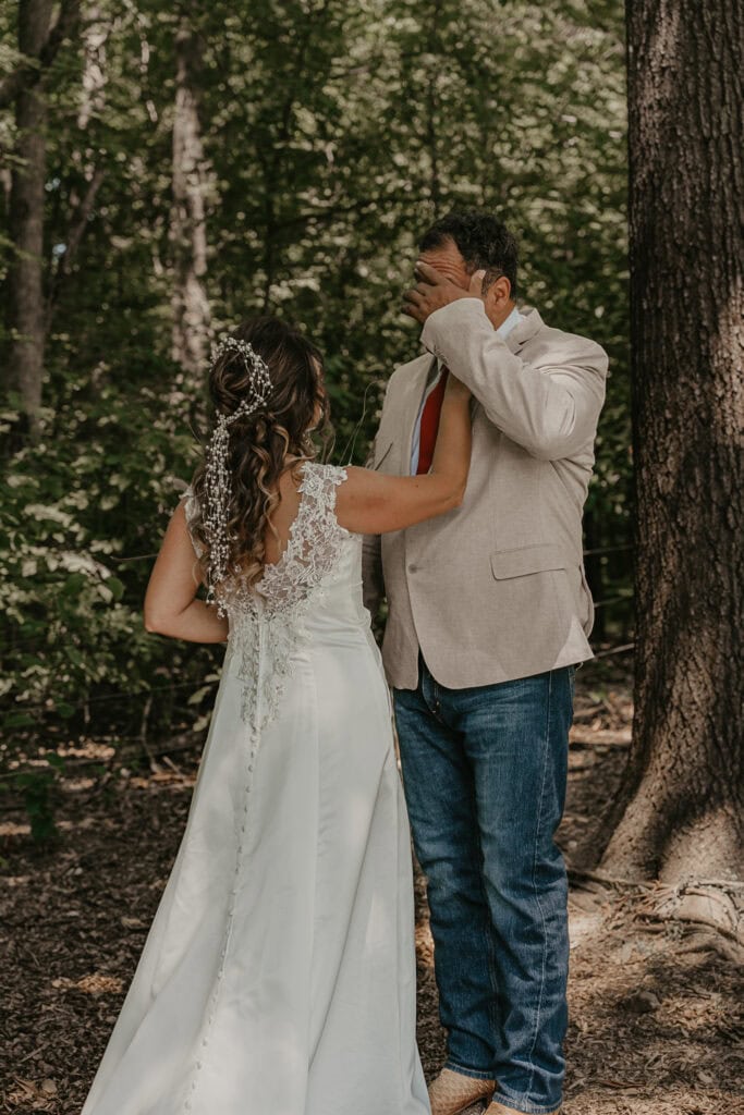 John wipes his eyes after seeing Anita in her wedding dress for the first time.