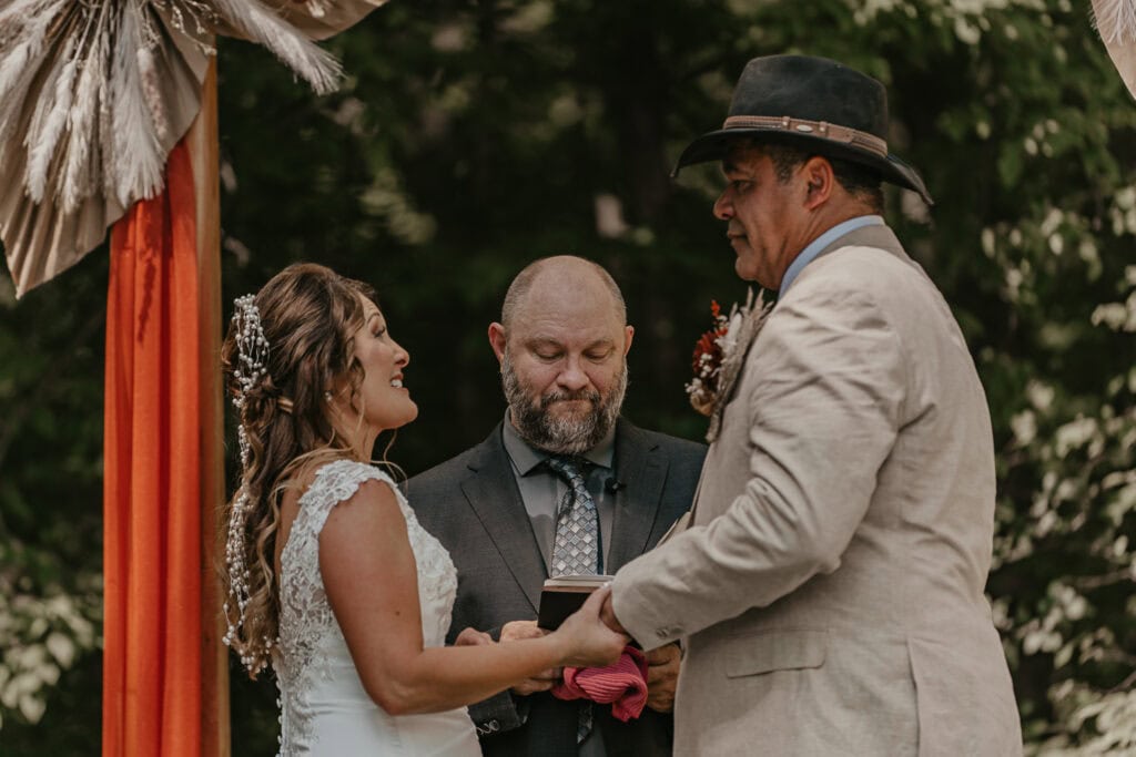 Bride and Groom hold hands as they begin the ring exchange portion of their wedding.