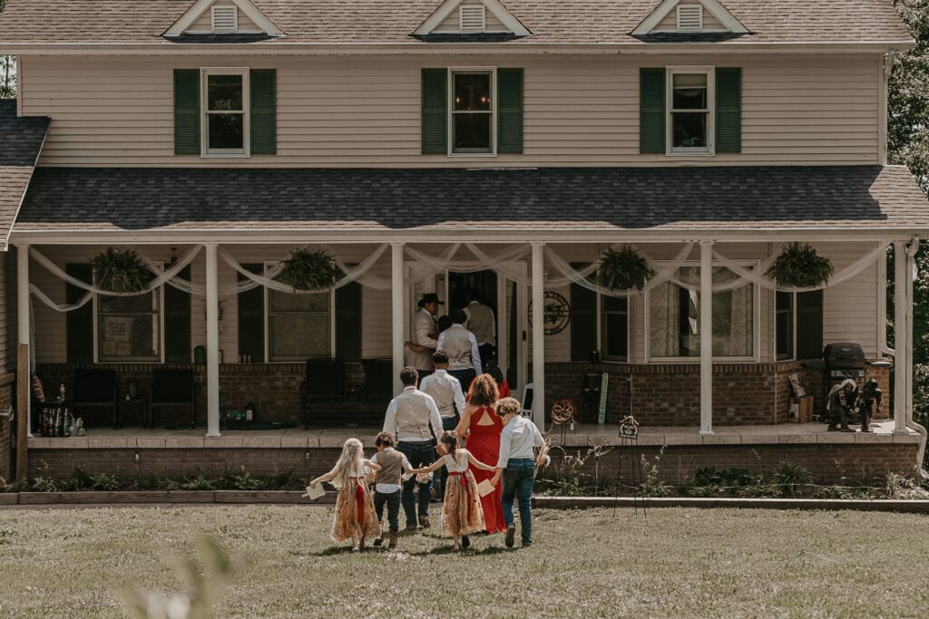 The wedding party walks into the bride and groom's home after their backyard ceremony is complete.