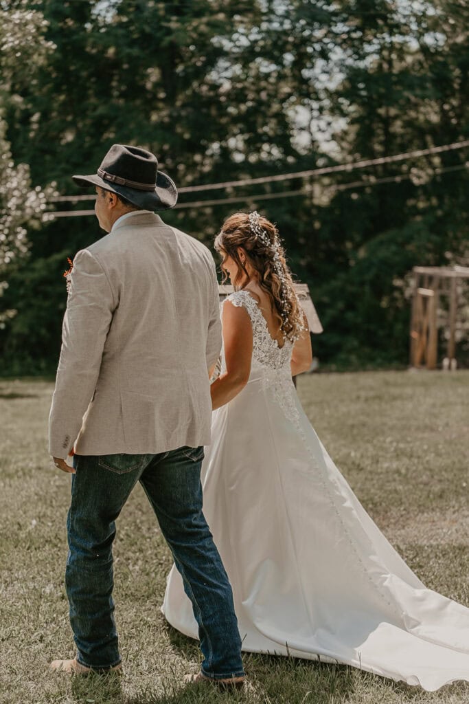 John and Anita hold hands and walk away from their ceremony after it's over.