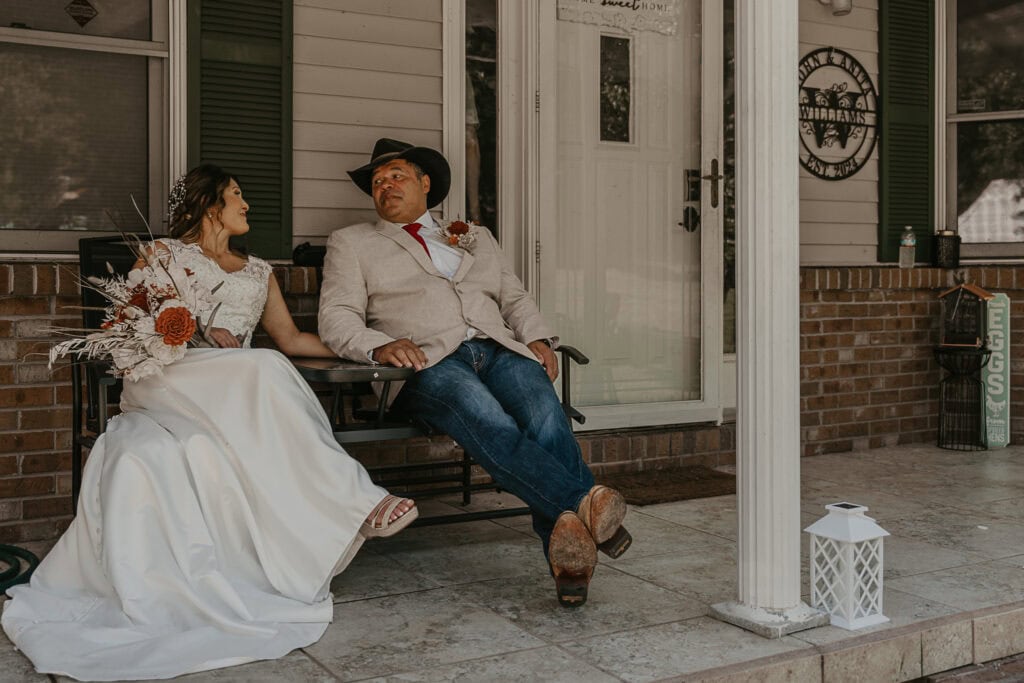 John and Anita sit on their front porch together, taking a moment to relax on their wedding day.