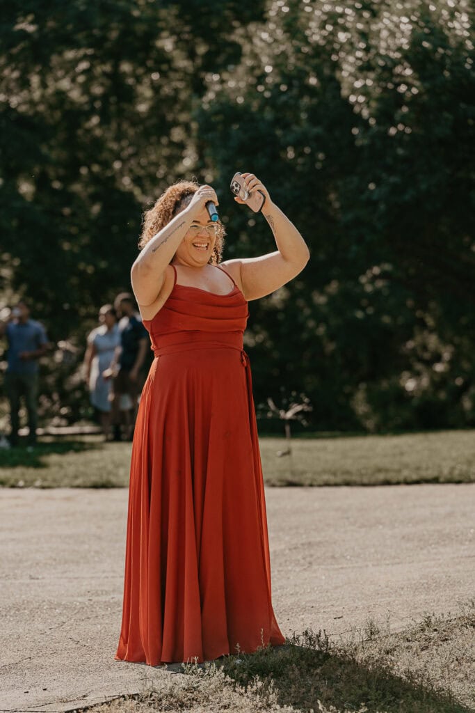 A bridesmaid toasts the bride and groom during their outdoor reception.