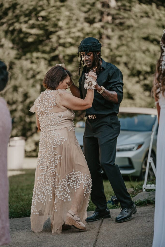 Two people dance at a backyard wedding reception.