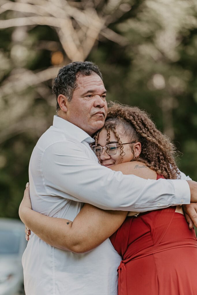 An emotional pair, dad hugs his daughter at his wedding.