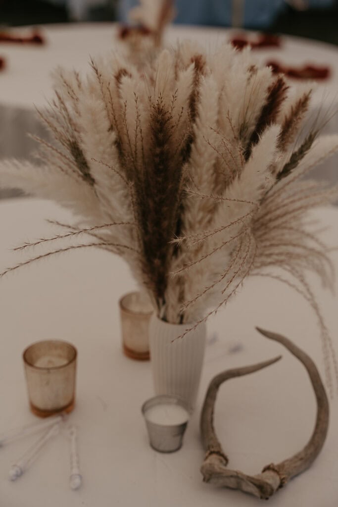 Bridal table decorations in neutral colors with a small set of antlers.