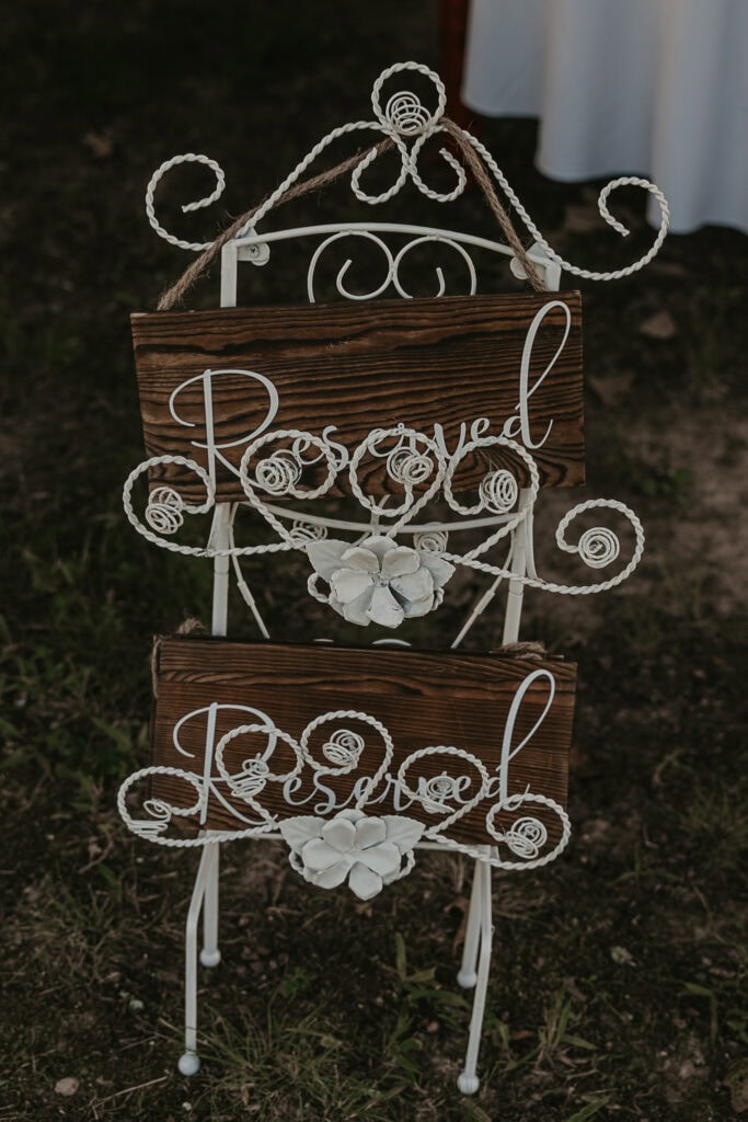 Wooden reserved signs in a metal scrolled holder outside a reception area.