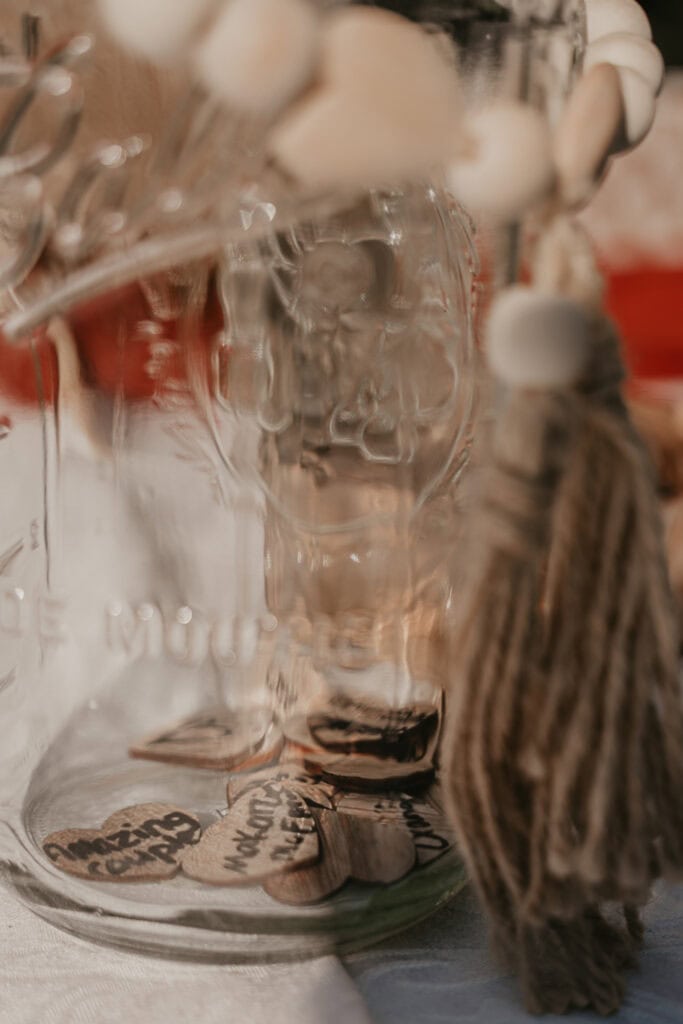 A glass mason jar full of wooden hearts.