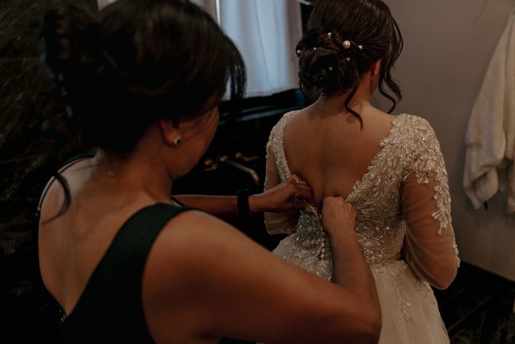 Amaris' mom zips up her wedding gown.