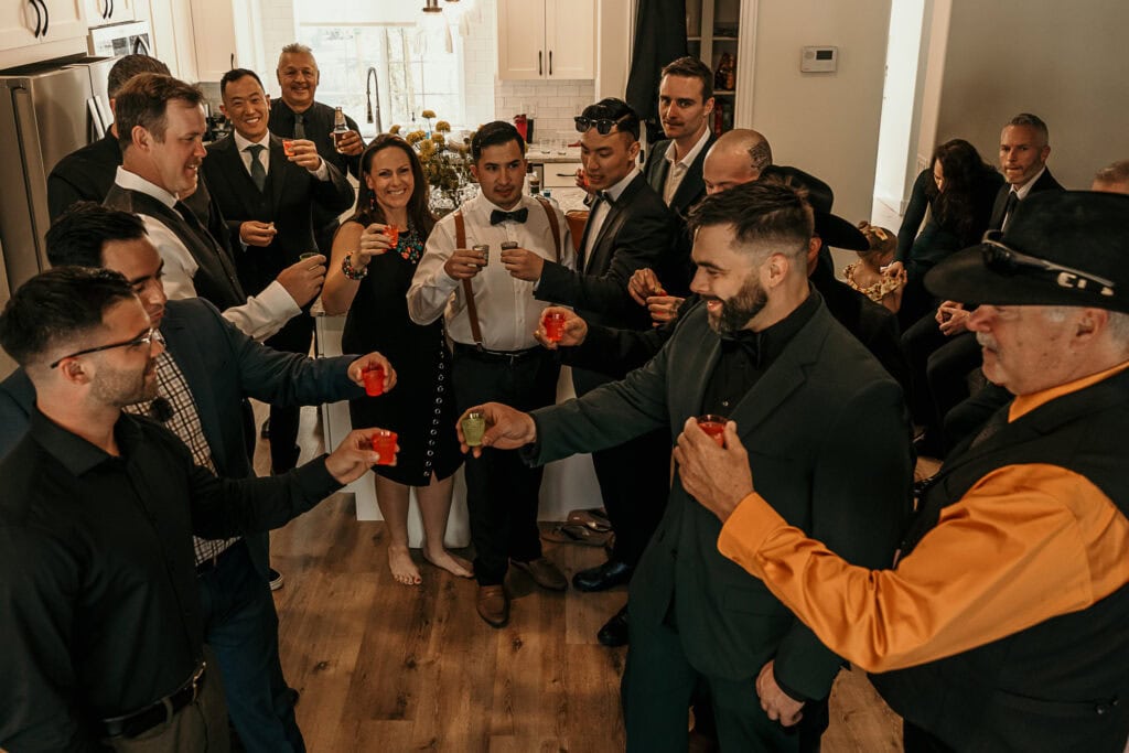 A group of family and friends takes a shot together with Kyle on his wedding day.