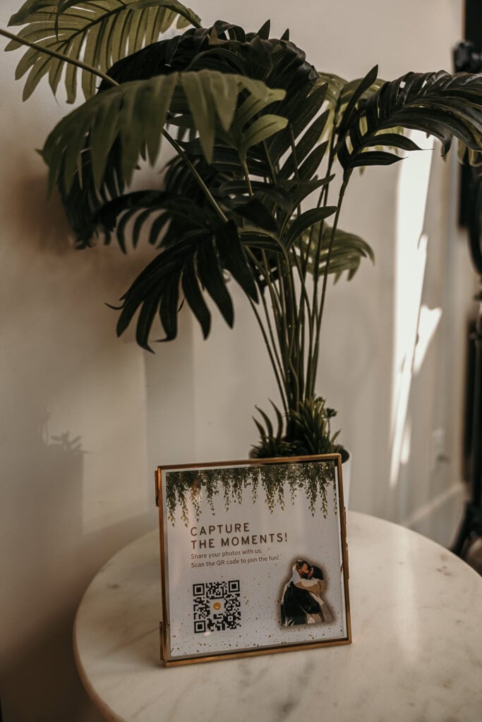 A sign with a QR code is on a table at a bride and groom's AirBnB.