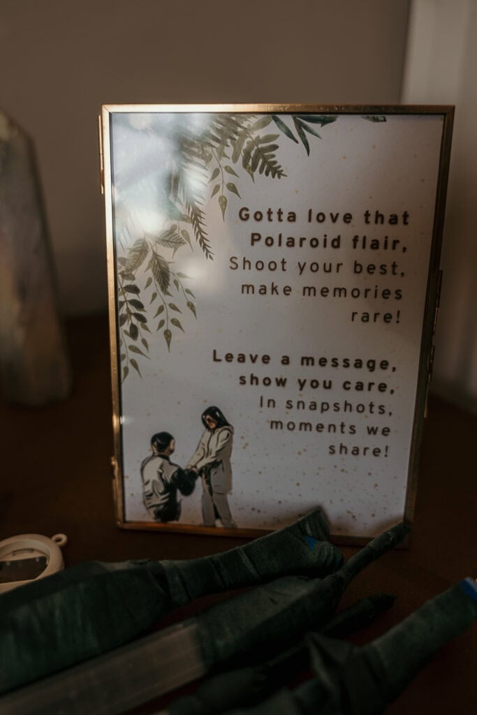 A sign on a wedding reception table inviting guests to take polaroids.