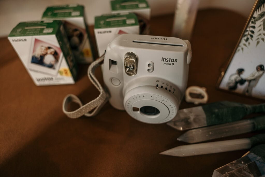 A polaroid camera and extra film on a table at a wedding reception.