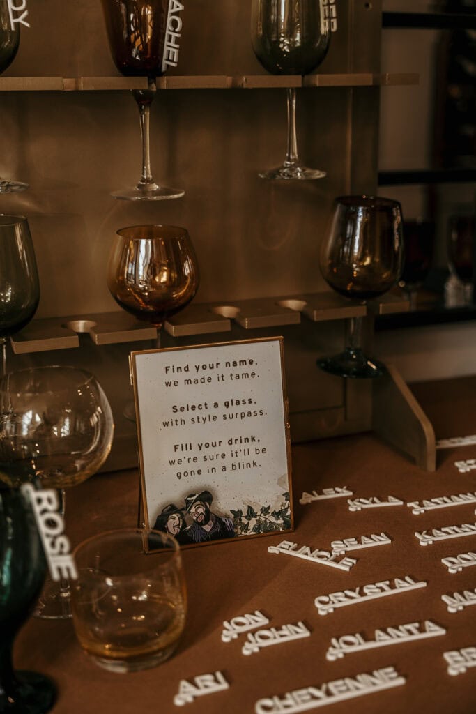 Plastic name tags on a table with glasses and instructions on how to attach them at a reception.