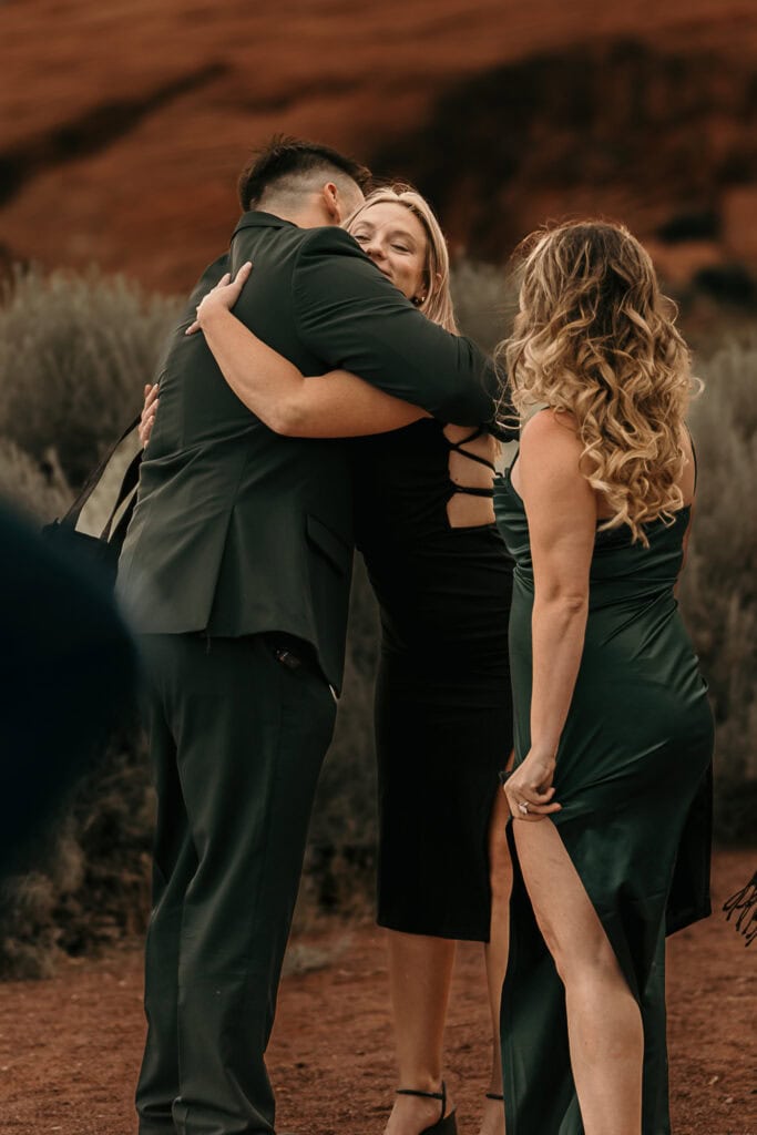 A groom hugs one of his friends after his wedding.